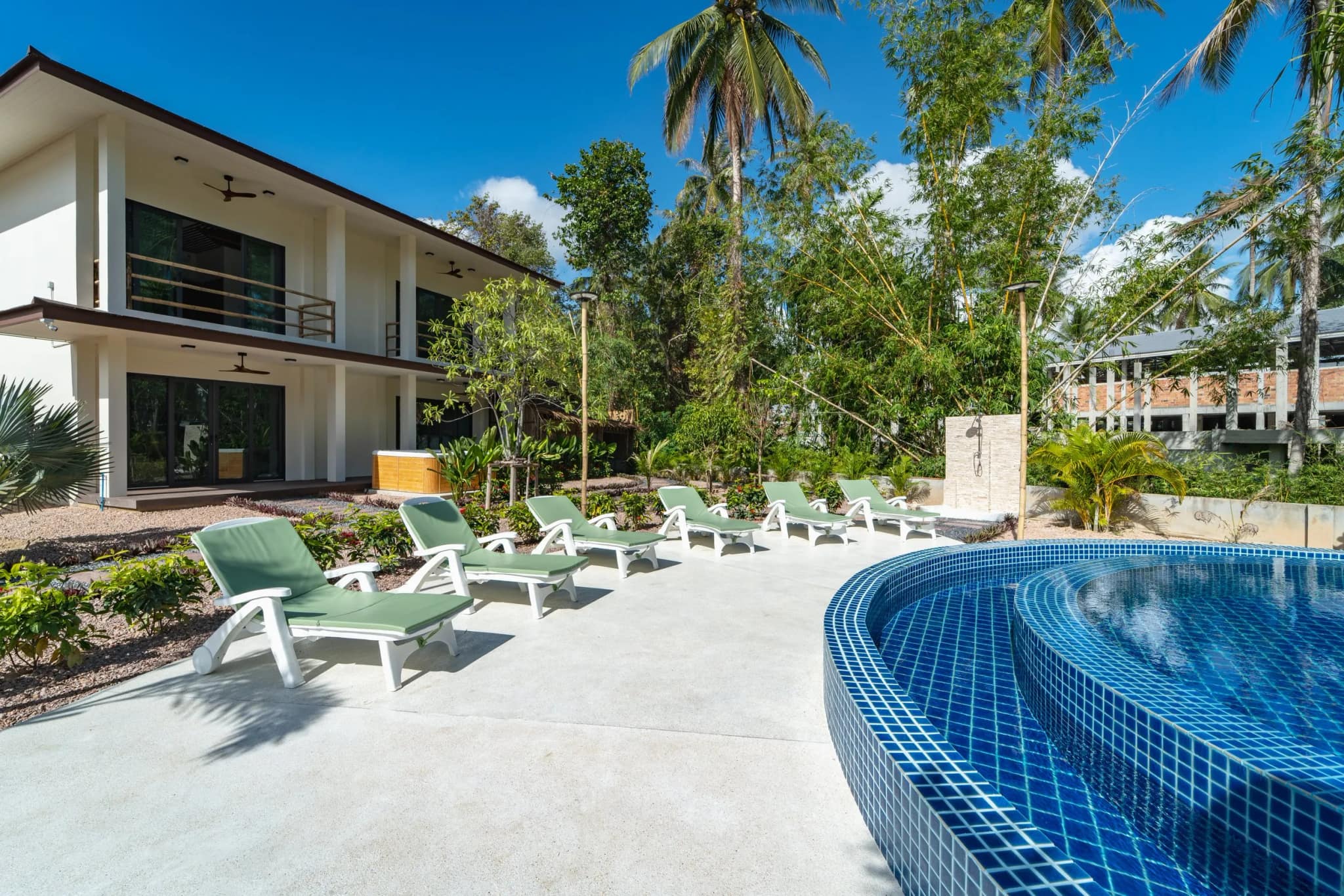 Swimming pool with loungers and umbrellas at SHI Phangan Villas